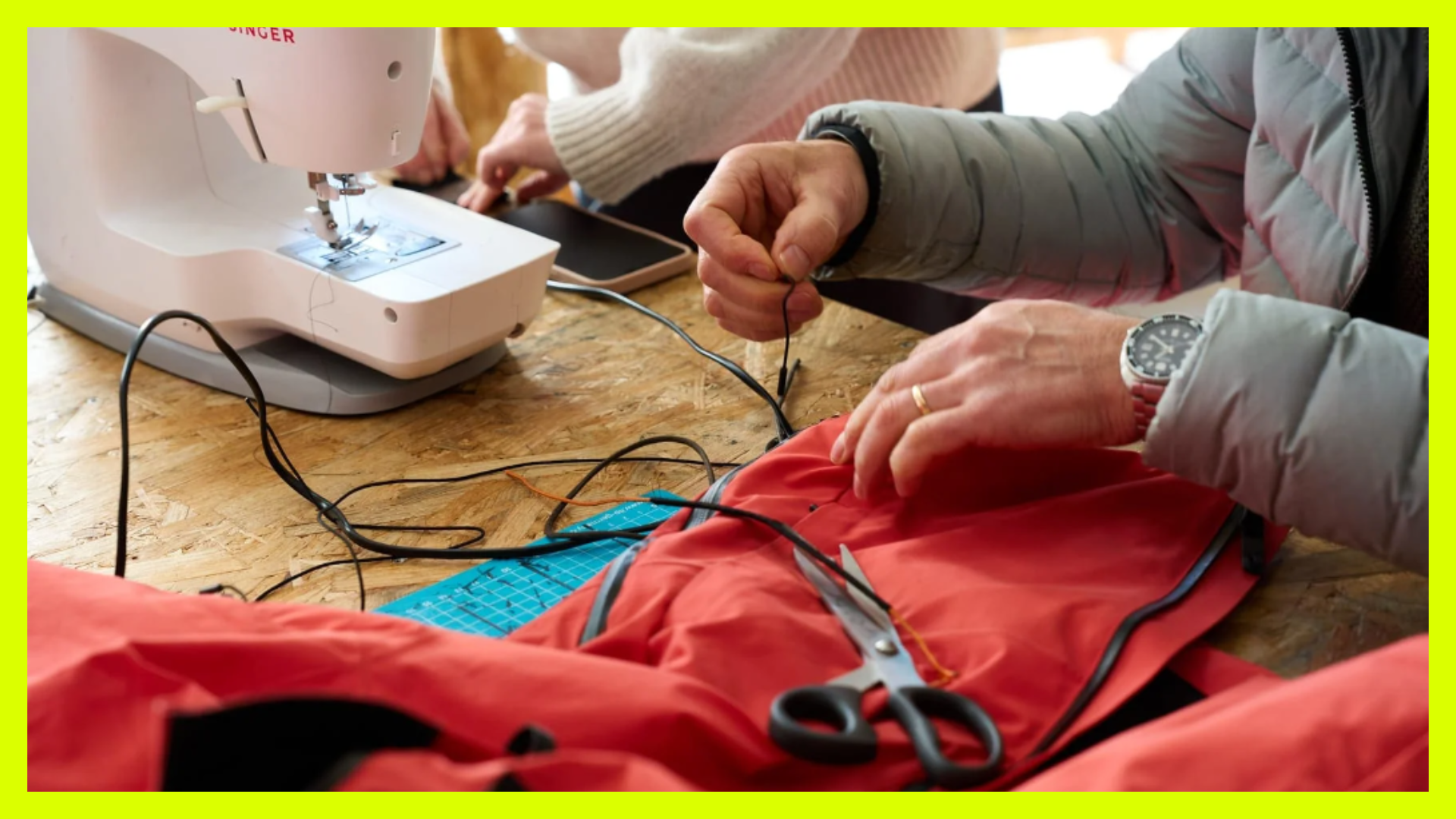 People at a repair cafe, fixing clothes with sewing machines